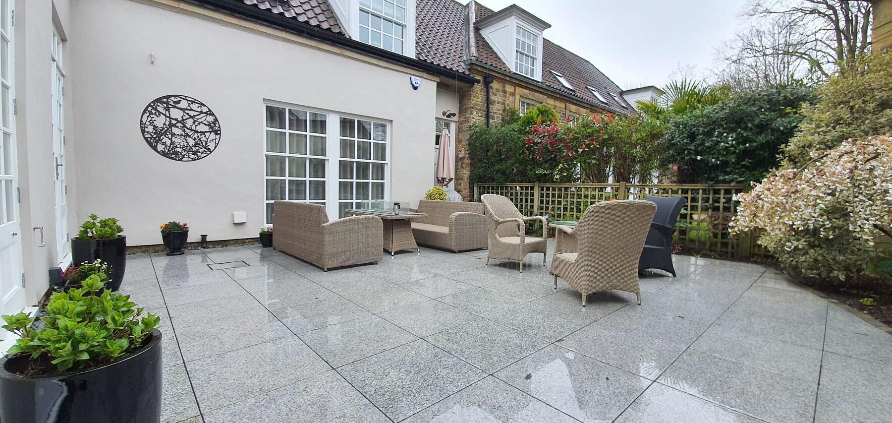 Completed spacious courtyard patio with modern paving and outdoor seating